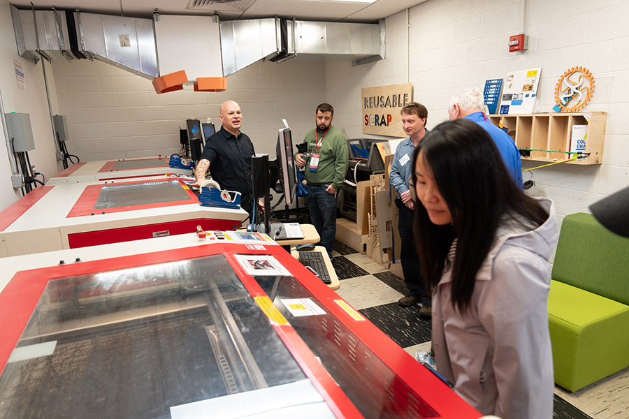 McKelvey explains laser cutter access and use to visitors on a tour of the basement labs.