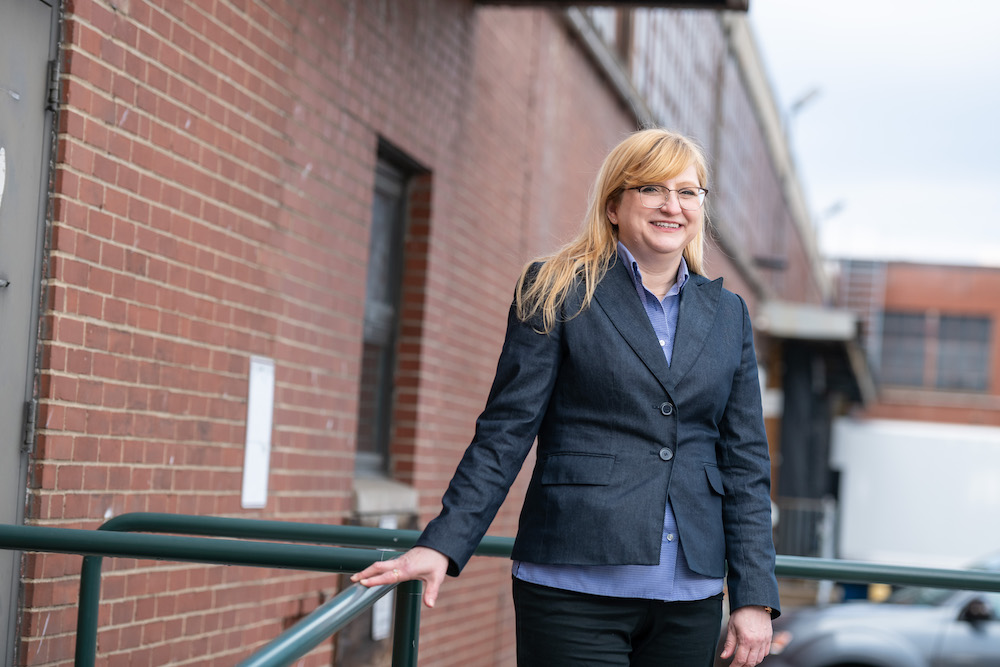 Ann Marie Mesco standing next to brick wall