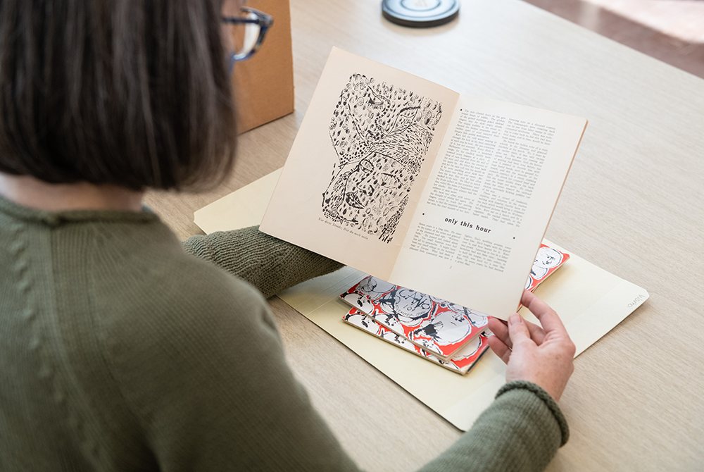 Image of Project Archivist, Emily Davis, looking at the Andy Warhol cover of Cano while working in the University Archives.  