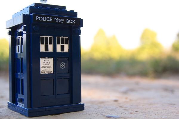 The TARDIS (the Doctor's mode of travel in Doctor Who) sits in the foreground of the image.