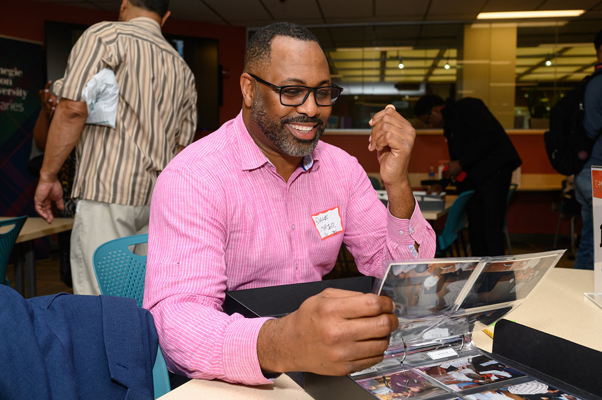 David Major, associate dean of Diversity, Equity, Inclusion, and Belonging at Tepper School of Business checks out the photo albums.