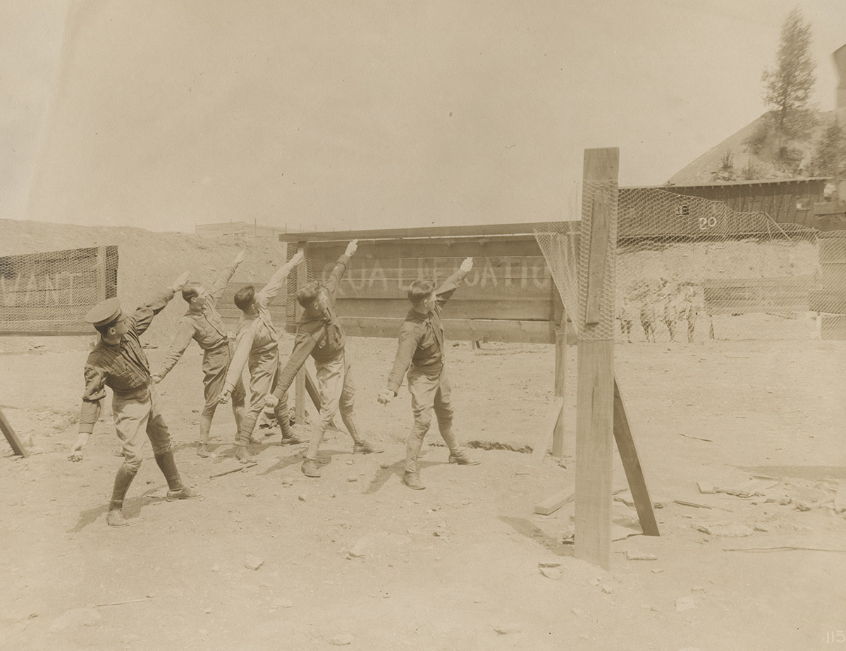 Soldiers learn to throw hand grenades by throwing rocks as part of their bomb throwing training on the campus of the Carnegie Institute of Technology.