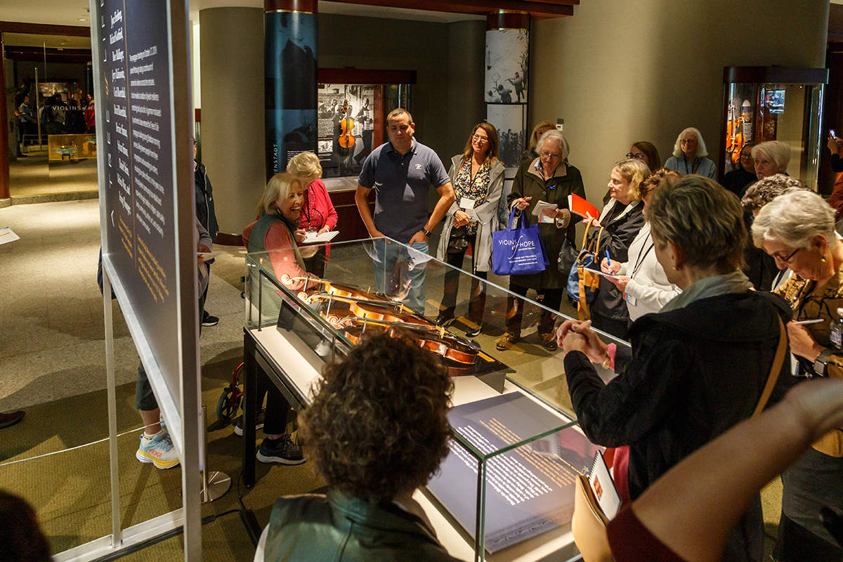 Avshi Weinstein, co-founder of Violins of Hope, leads docents through the exhibition.