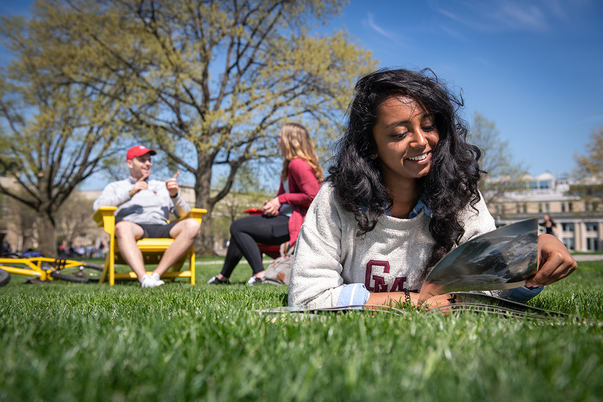 student reading in the grass