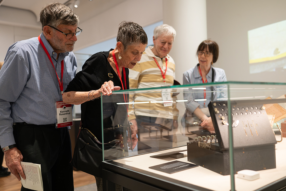 A group examines a WWII-era Enigma machine.