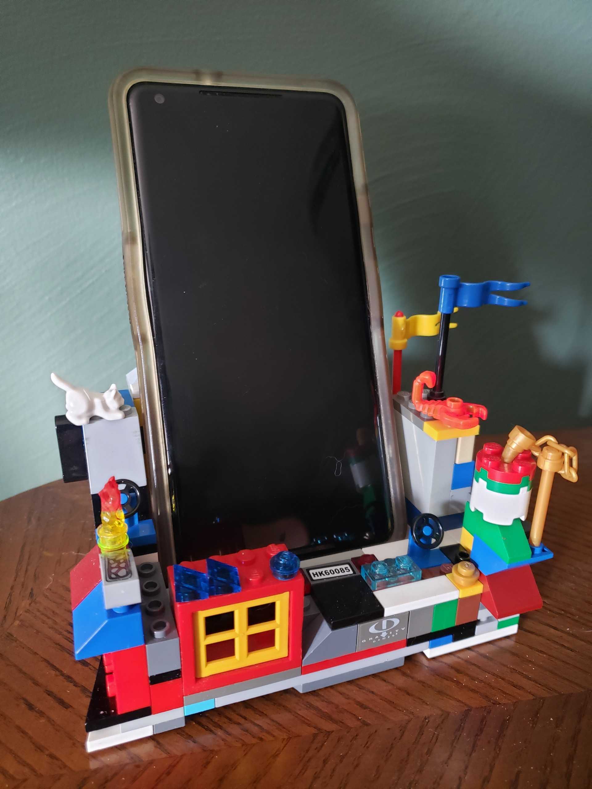 Image description: Hannah's cell phone sitting in her DIY stand made out of Legos, which includes lots of disparate shapes and colors.