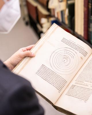 Image of Sam Lemley reading Copernicus. 