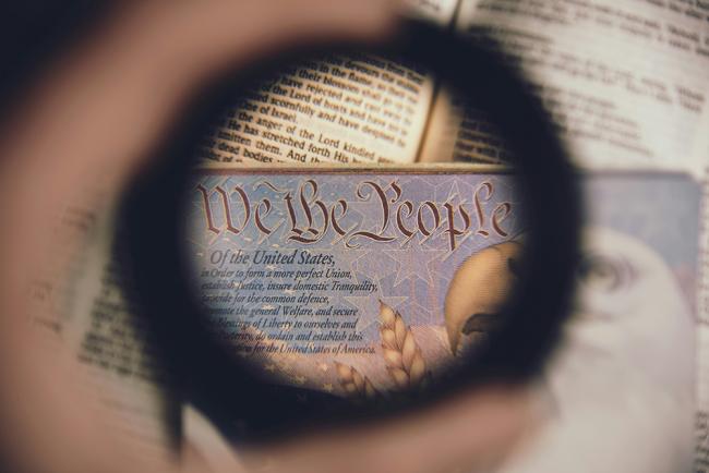 Magnifying glass over the US Constitution. Photo by Anthony Garand on Unsplash.